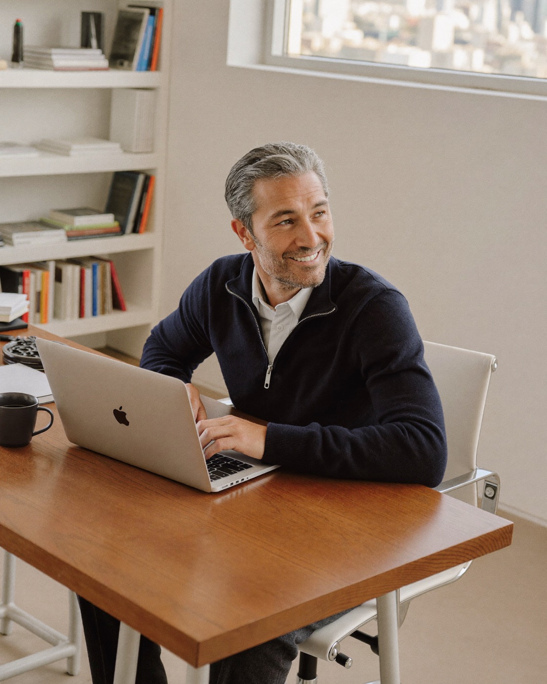 A business owner working at his desk in a bright office above his workshop